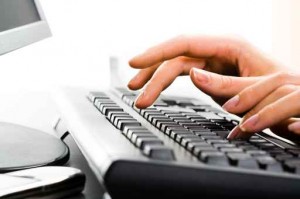 A business ladys hands on the keys typing documents